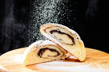 wo üzerinde taze pişmiş tarçın rulo ile pudra şekeri serpilir