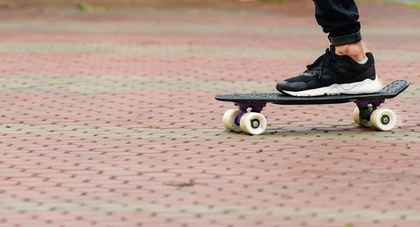 Primo piano di skateboarders piedi in scarpe da ginnastica su skateboard su strada — Foto Stock