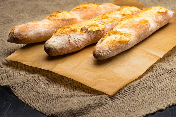 Still life with three French fresh bread baguettes with poolish, — Stock Photo, Image