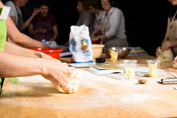 woman baker sprinkled flour on roll dough on a wooden board. Pro