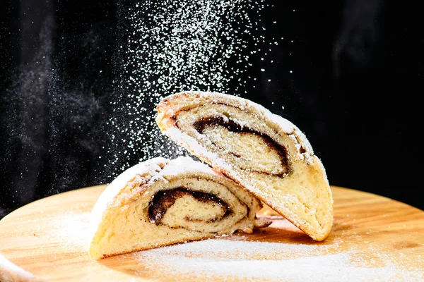 wo üzerinde taze pişmiş tarçın rulo ile pudra şekeri serpilir