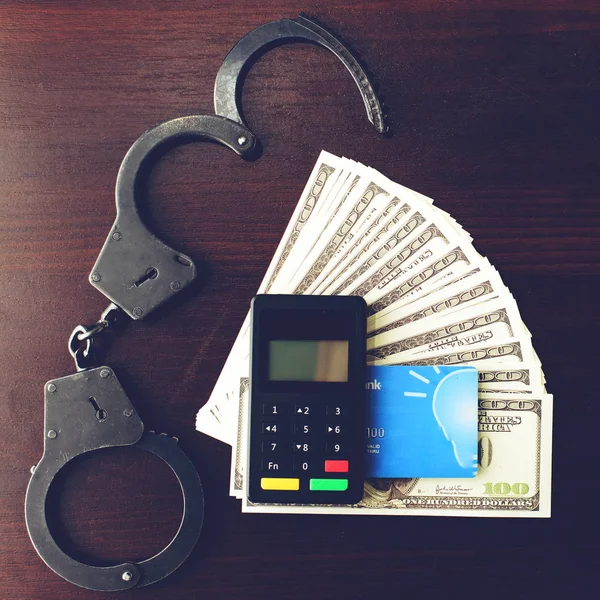 steel police handcuffs, dollars money, payment device and bank c