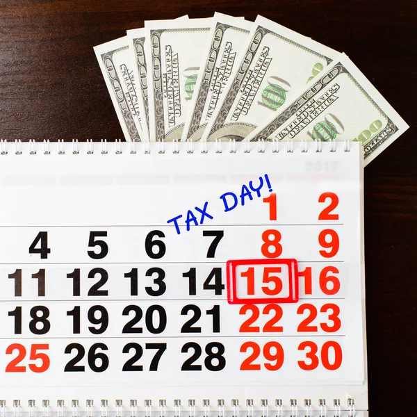Dólares em dinheiro, 15 de abril no calendário e frase Dia do Imposto, b de madeira — Fotografia de Stock