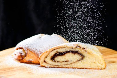 wo üzerinde taze pişmiş tarçın rulo ile pudra şekeri serpilir