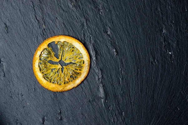 Fatia amarela seca de limão no fundo escuro, espaço de cópia para tex — Fotografia de Stock