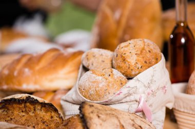 ön plan üzerinde geleneksel yuvarlak esnaf buğday ekmek somunları sepetin içinde. Ve arka plan üzerinde başka bir ekmek. Rustik tarzı, seçici odak