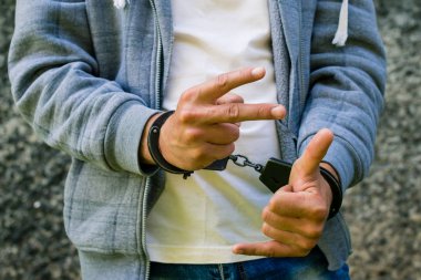 Genç ceza ayakta açık havada kelepçeli. Suç kavramı