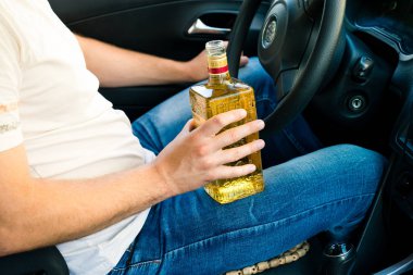 bir arabanın direksiyonuna oturan ve alcoho içme sarhoş adam