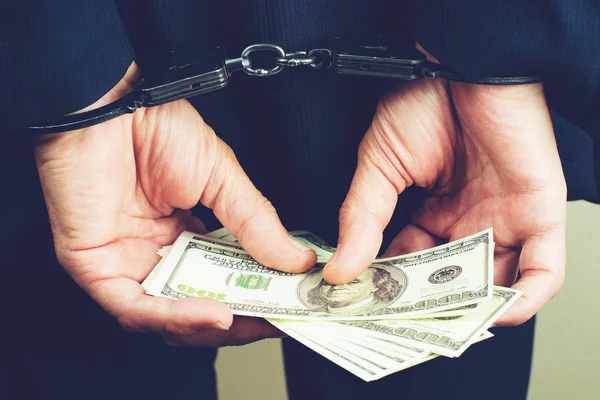 Arrested official in handcuffs counting dollar banknotes. Concep — Stock Photo, Image