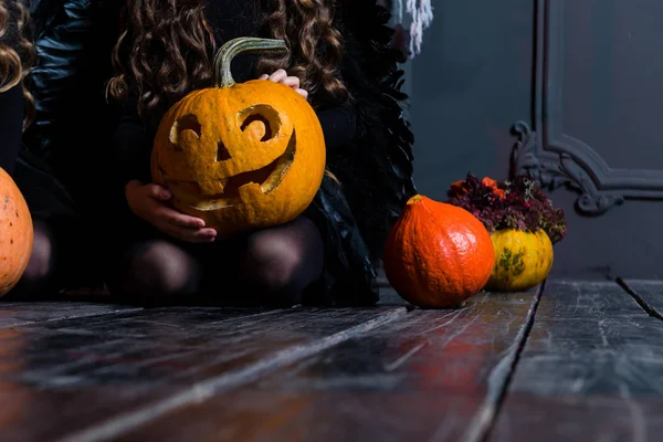 Chica sentada cerca de la calabaza de Halloween cabeza jack linterna en dar —  Fotos de Stock