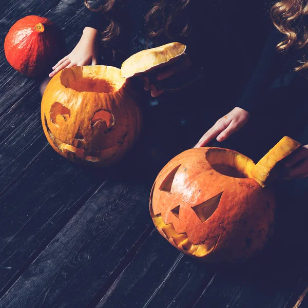 Chicas sentadas con la calabaza de Halloween cabeza jack linterna en da —  Fotos de Stock