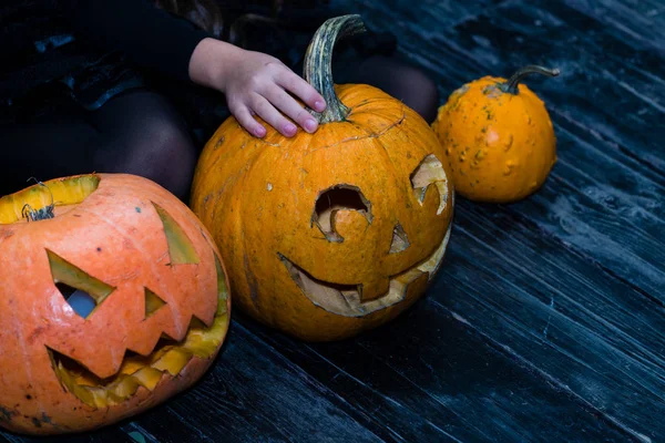 Chica sentada cerca de la calabaza de Halloween cabeza jack linterna en dar —  Fotos de Stock