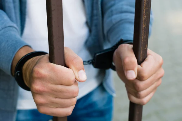 Руки бизнесмена в наручниках за решеткой тюрьмы. H — стоковое фото