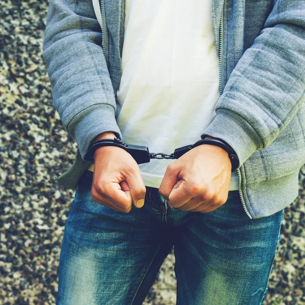 Genç ceza ayakta açık havada kelepçeli. Suç kavramı