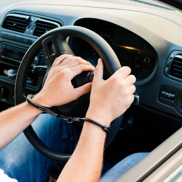 Gefesselte Hände eines Täters, der am Steuer eines Autos saß — Stockfoto