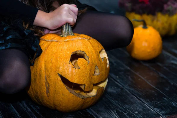 Chica sentada cerca de la calabaza de Halloween cabeza jack linterna en dar —  Fotos de Stock