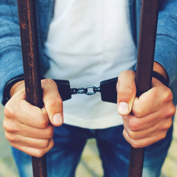 bir işadamı bir cezaevi parmaklıklar arkasında elleri kelepçeli. H