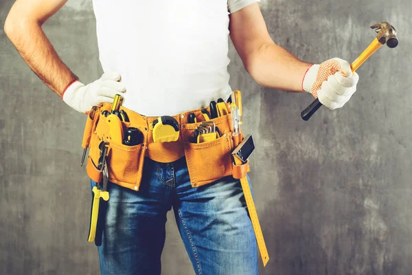 Unidentified builder standing in white gloves with a tool belt w — Stock Photo, Image