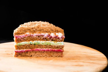 Yakın çekim yuvarlak ahşap bo üzerinde tatlı ev yapımı katmanlı bal pasta