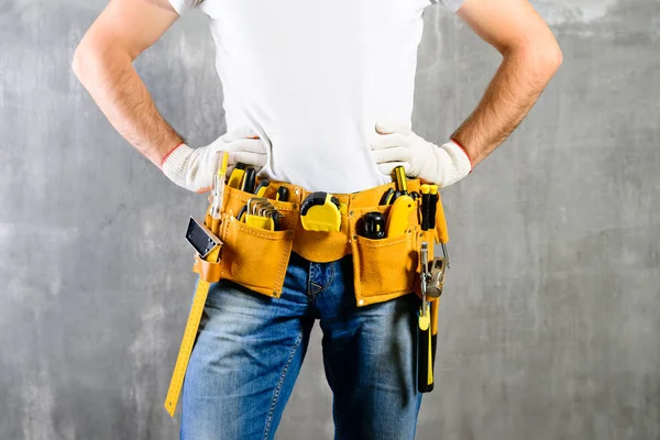 Okänd handyman med händerna på midjan och verktyget bälte med konstruer — Stockfoto