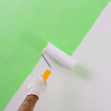 Erkek el boyama duvar boya silindiri ile. Yeni apartmen boyama