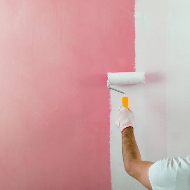 Erkek el boyama duvar boya silindiri ile. Yeni apartmen boyama