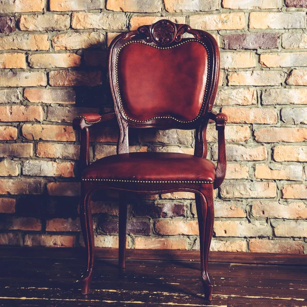 Brauner Lederstuhl im Raum vor gemauertem Hintergrund, getönt — Stockfoto