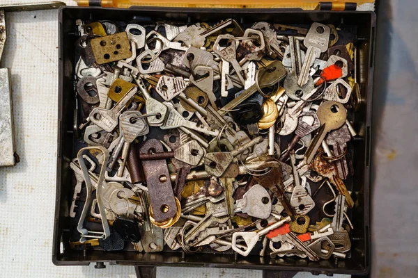 Vista dall'alto di un mucchio di diverse chiavi antiche arrugginite nel nero — Foto Stock