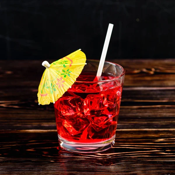 Kırmızı buz küpleri ve saman umbre ile kokteyl cam üstten görünüm