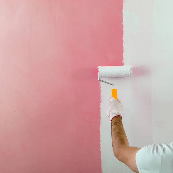 Maschio pittura a mano parete con rullo di vernice. Pittura nuovo apartmen — Foto Stock