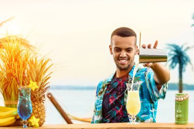 Barın yakınında duran yakışıklı gülümseyen Latin Amerika barmen 