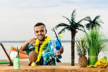 Barın yakınında duran yakışıklı gülümseyen Latin Amerika barmen 