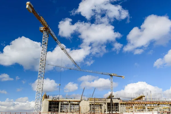 Construction site with cranes and buildings against blue sky. Hi — Stock Photo, Image