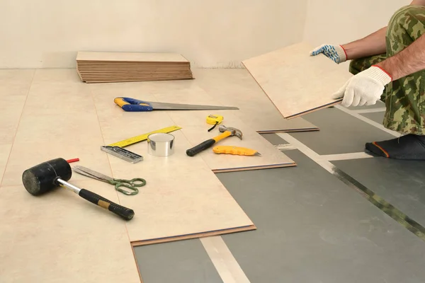 Carpenter worker installing wood parquet board during flooring w — Stock Photo, Image