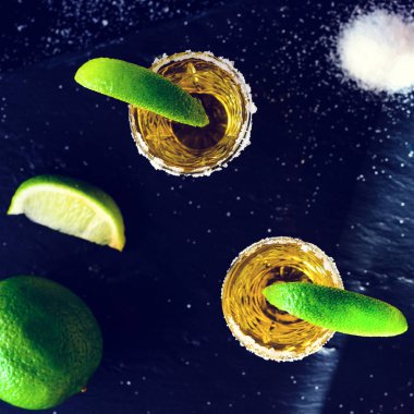 Limon ve tuz karanlık masada altın Meksika tekila. Üstten görünüm,