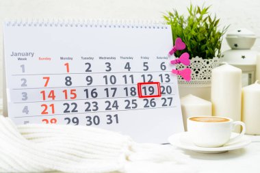 Ocak 19. C bir fincan yakınındaki beyaz takviminde ayın gün 19