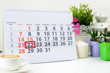 22 Ocak. C bir fincan yakınındaki beyaz takviminde ayın gün 22