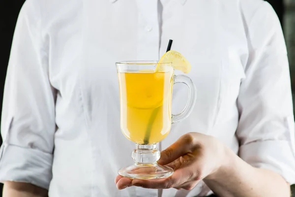 Il cameriere non identificato che tiene un bicchiere con grog caldo con limone — Foto Stock