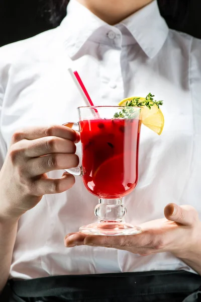 Der unbekannte Kellner hält ein Glas mit heißem Preiselbeergin in der Hand — Stockfoto