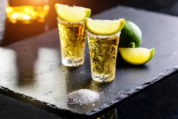 Tequila de oro mexicano con cal y sal en barra de piedra —  Fotos de Stock