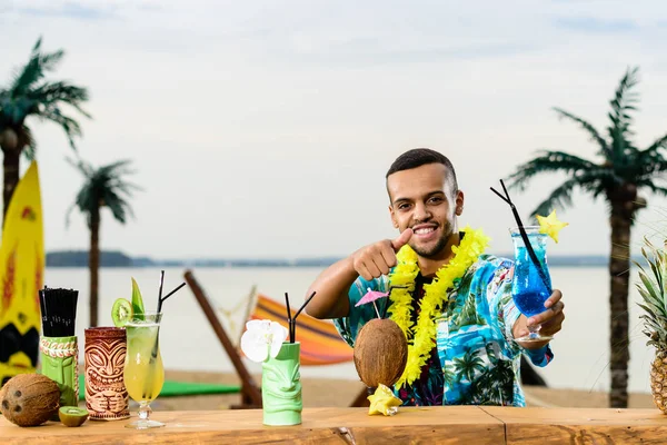 Barın yakınında duran yakışıklı gülümseyen Latin Amerika barmen 