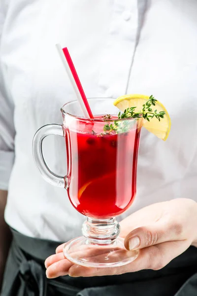Der unbekannte Kellner bringt einen heißen Preiselbeer-Gin-Cocktail für — Stockfoto
