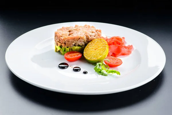 Смачний тунець Тартаре з лаймом, імбиром та авокадо в білій тарілці — стокове фото