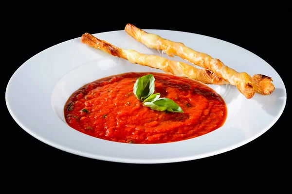 Deliziosa zuppa di pomodoro decorata con basilico e bastoncini di pane isol — Foto Stock