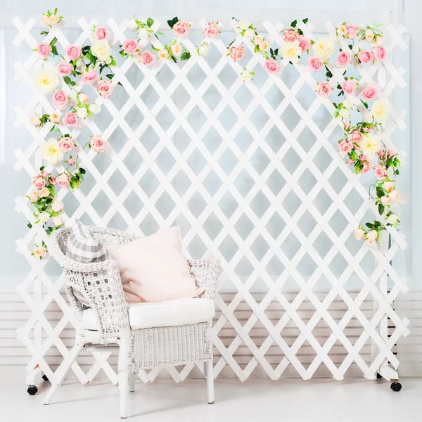 Leichtes Interieur mit Stuhl und weißem Zaun mit Blumen — Stockfoto