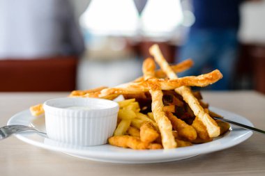 Lezzetli kızarmış patates, kruton ve beyaz bir tabak içinde sos bir