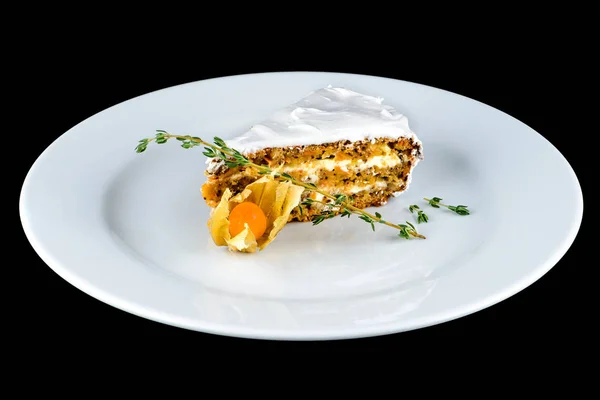Appetizing piece of carrot cake in a white plate on dark backgro