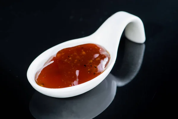 Острый острый соус в специальной белой ложке — стоковое фото
