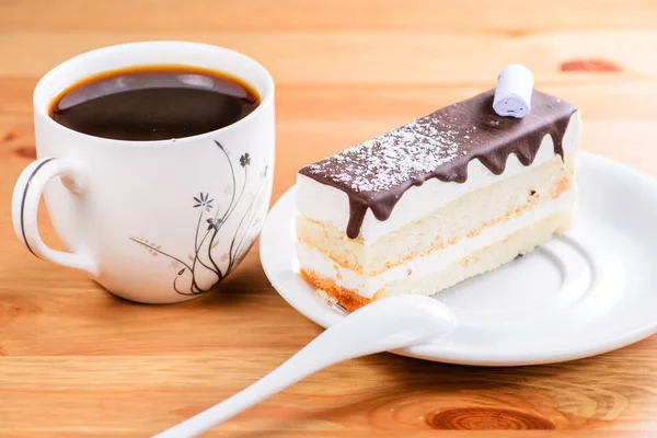 Scheibe köstlichen süßen Glasurkuchen und Tasse Kaffee auf — Stockfoto