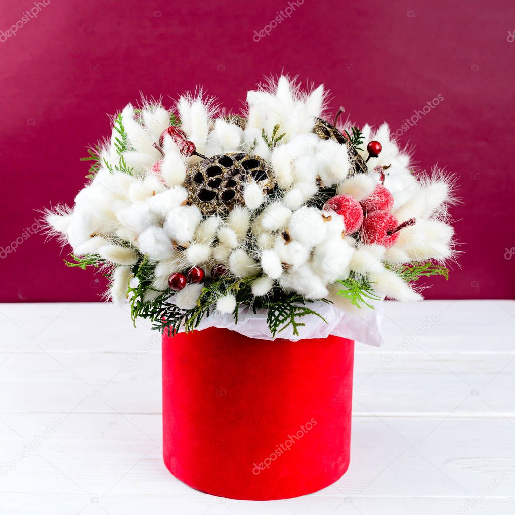 Beautiful creative decorative winter bouquet with berries, cotto